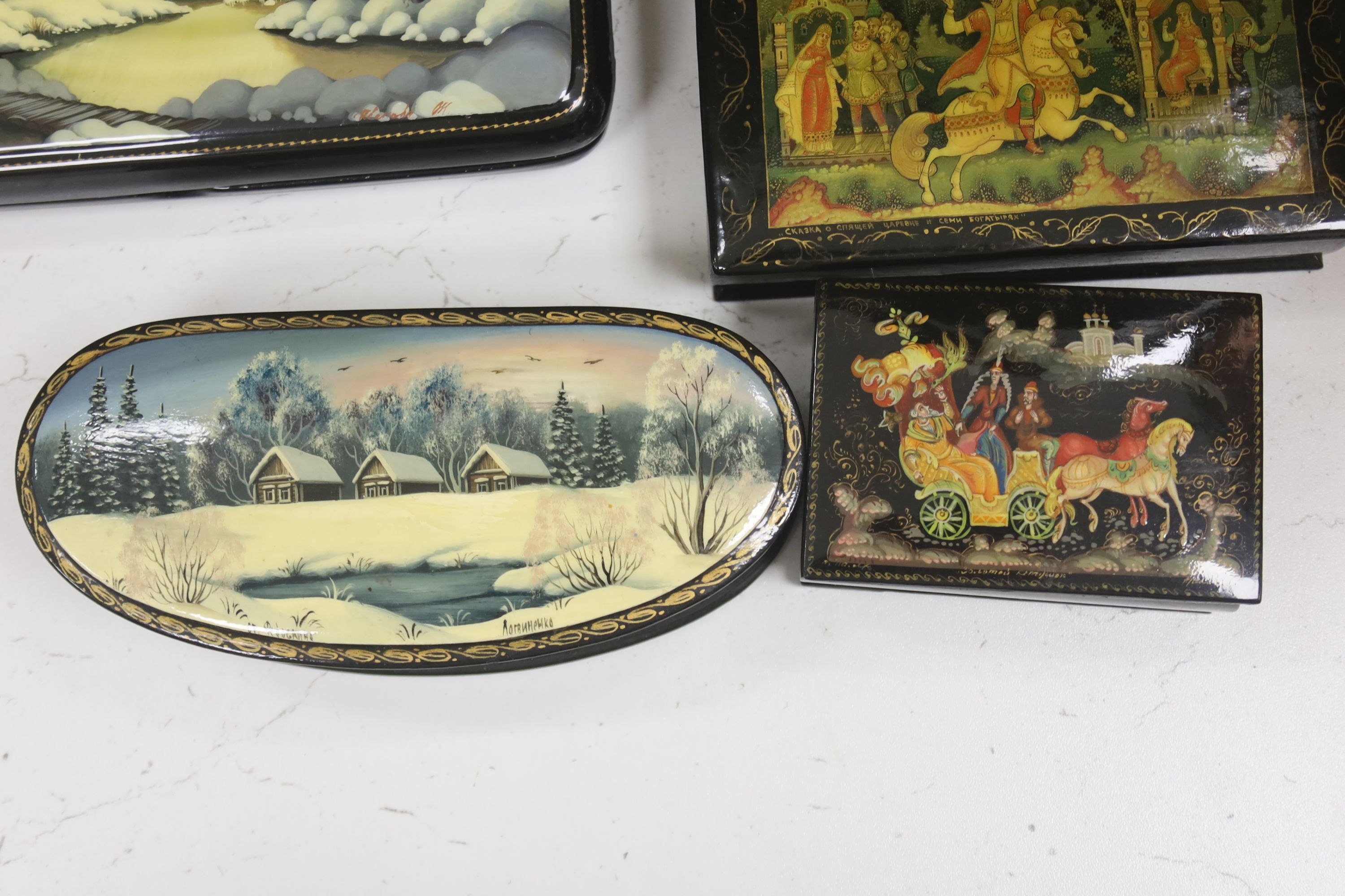 A collection of seven Russian painted lacquer boxes, largest raised on bracket base 15 x 20cm 9.5cm high